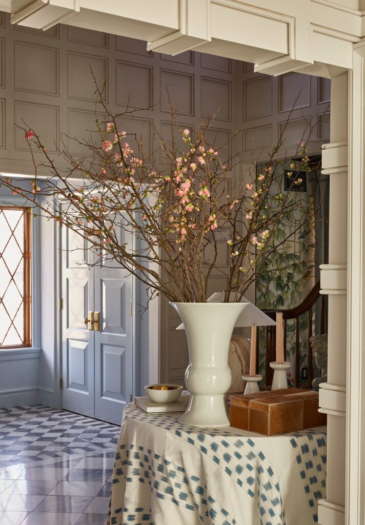 Elegant completed foyer with updated staircase, curved spindle railing, and timeless black-and-white checkerboard floors.