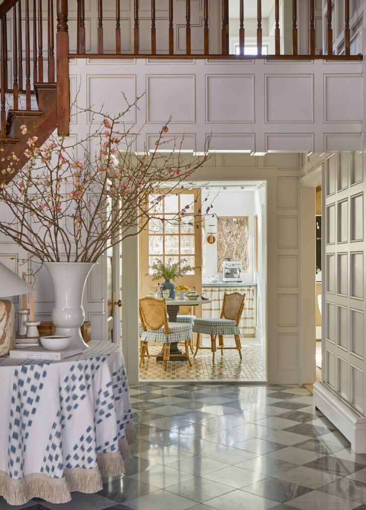 Finished foyer of the renovated Tudor home featuring classic checkerboard flooring, refined architectural details, and a bright welcoming entry.