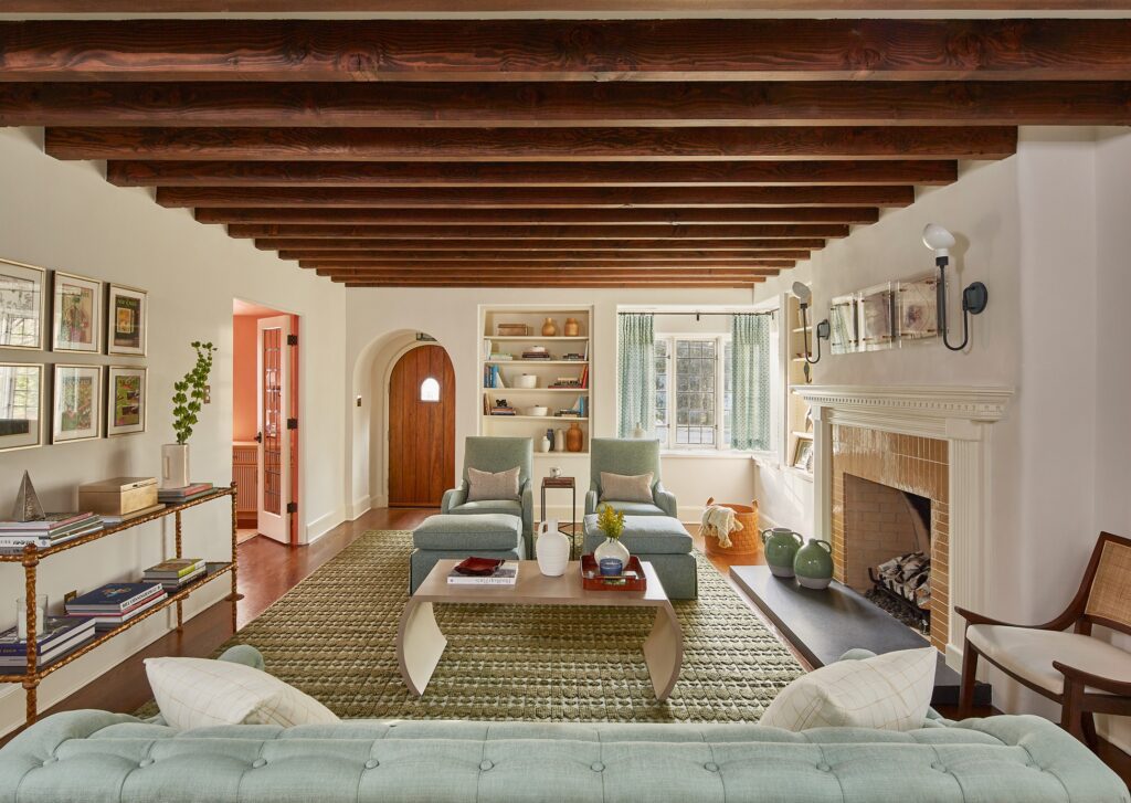 scarsdale new york colorful pattern filled tudor living room with mint green accents, traditional fireplace, arched door way family friendly luxury interior design