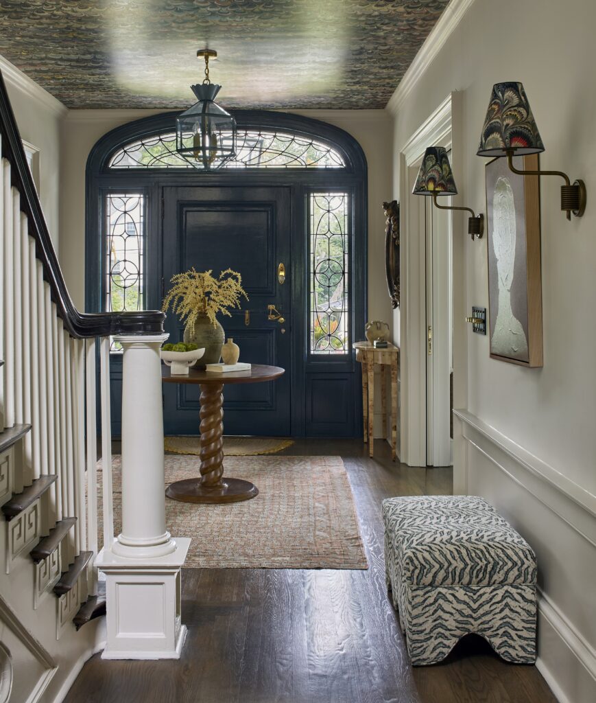 Foyer of a Chatham, NJ center hall Colonial with wallpapered ceiling, teal Dutch door and vintage rug.